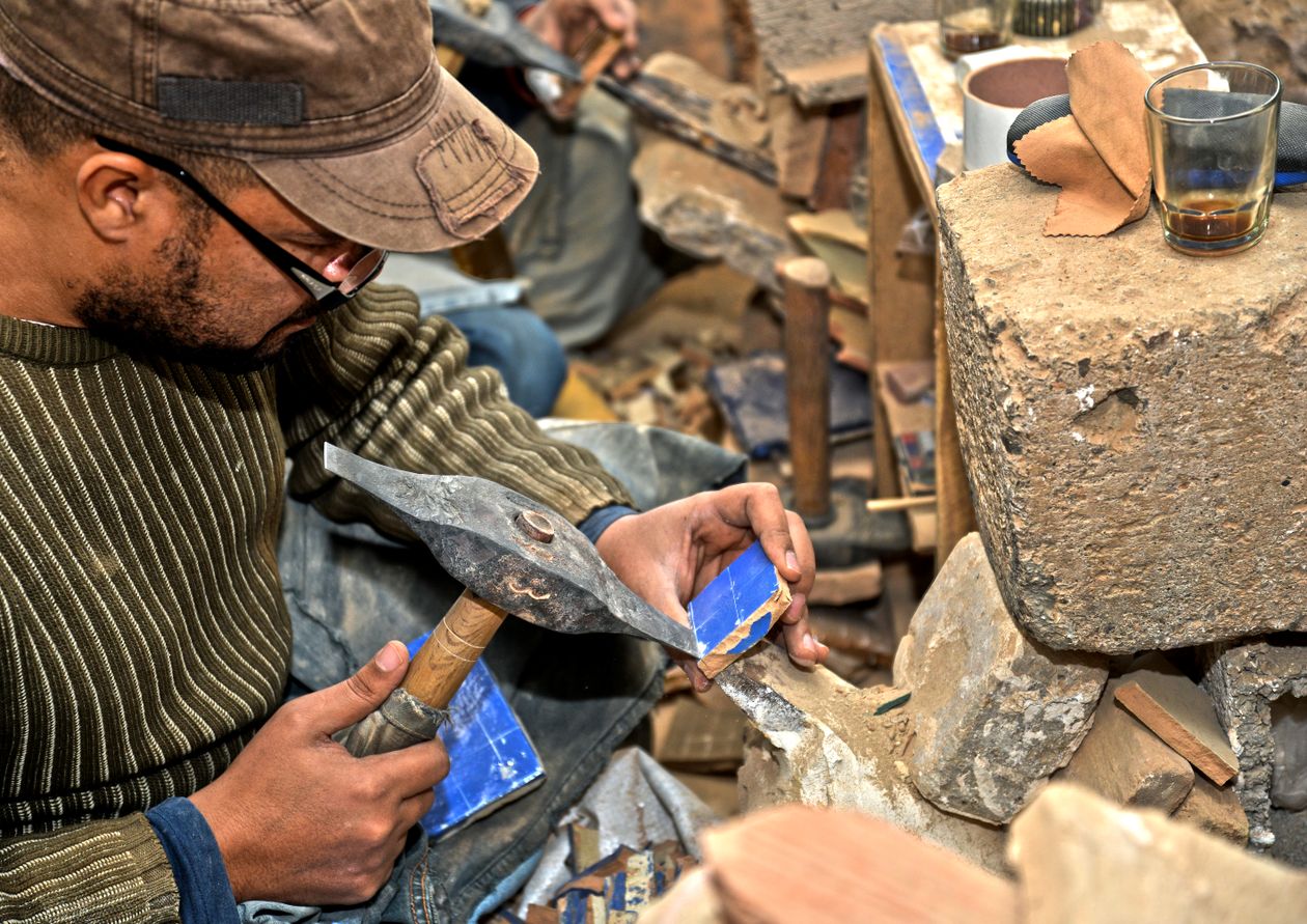 Zellige artisan cutting tiles in Fes